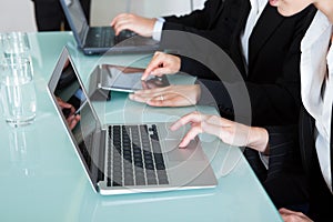 Businesspeople working on laptops and tablets