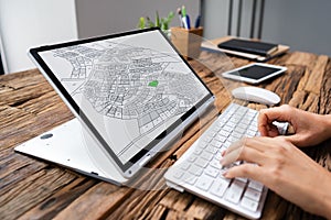 Businessperson Analyzing Cadastre Map On Computer photo