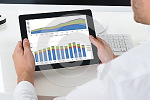 Businessperson Analyzing Graph On Digital Tablet