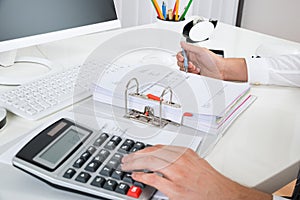 Businessperson Calculating Budget At Desk