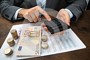 Businessperson calculating finance on desk