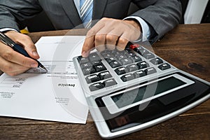 Businessperson calculating financial sheet