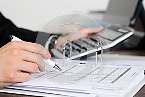 Businessperson Calculating Invoice In Office