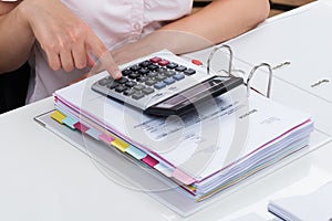 Businessperson Calculating Tax With Calculator photo