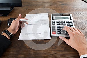 Businessperson Calculating Tax In Office