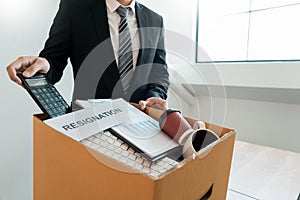 Businessperson carrying packing personal company on brown cardboard Box and resignation letters for quit or change of job leaving