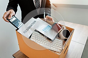 Businessperson carrying packing personal company on brown cardboard Box and resignation letters for quit or change of job leaving