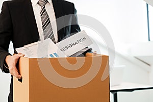 Businessperson carrying packing personal company on brown cardboard Box and resignation letters for quit or change of job leaving