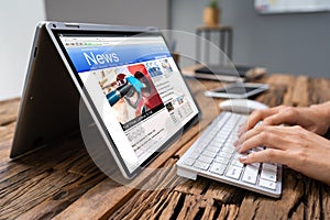 Businessperson Checking Online News On Laptop