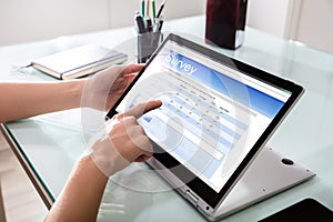 Businessperson Filling Online Survey Form On Digital Laptop