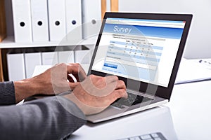 Businessperson Filling Online Survey Form On Laptop