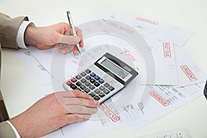 Businessperson hand calculating bills