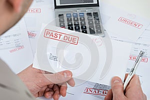 Businessperson hand with past due envelope photo