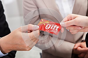 Businessperson Hands Giving Gift Card To Other Businessperson photo