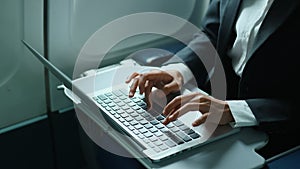 businessperson hands type on laptop keyboard while traveling on an airplane business 4K ,Businesswoman working on tablet