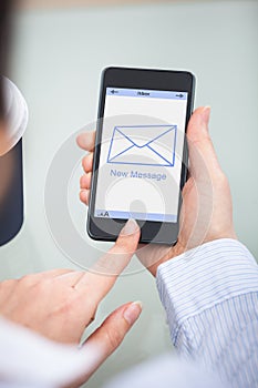 Businessperson holding cellphone with new message sign