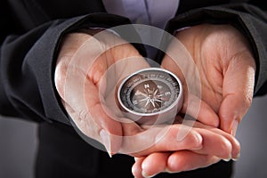 Businessperson holding compass