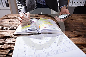 Businessperson Writing Schedule In Diary