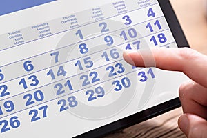 Businessperson Looking At Calendar On Tablet