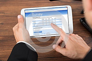 Businessperson with mobile phone showing survey form