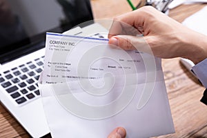 Businessperson Opening Envelope With Paycheck