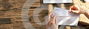 Businessperson Opening Envelope With Paycheck