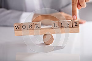 Businessperson`s Finger Showing Imbalance Between Work And Life