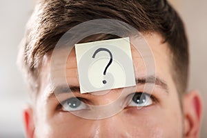 Businessperson`s Forehead With Question Mark On Sticky Note