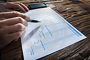 Businessperson`s Hand Analyzing Gantt Chart