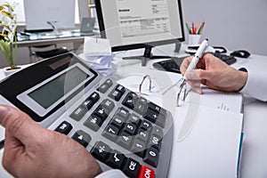 Businessperson`s Hand Calculating Bill