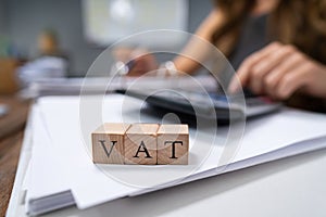 Businessperson`s Hand Calculating VAT With Calculator