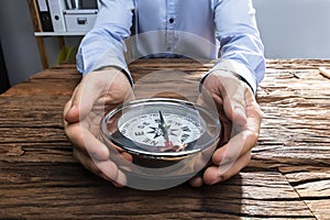 Businessperson`s Hand Holding Compass