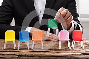 Businessperson`s hand picking up green chair