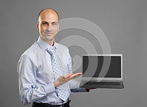 Businessperson showing a laptop with blank screen