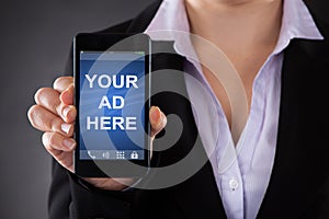 Person Holding Mobile Phone Showing Your Ad Here Text photo