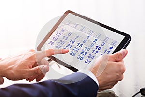 Businessperson Using Calendar On Digital Tablet