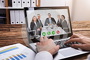 Businessperson Video Conferencing With Colleagues On Laptop