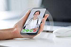 Businessperson Videochatting With Doctor On Smartphone