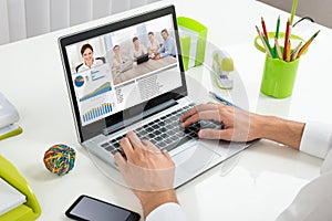 Businessperson Videoconferencing With Colleagues On Laptop