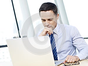 Businessperson working in office with laptop