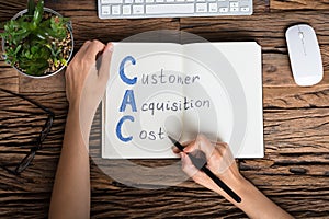 Businessperson Writing Customer Acquisition Cost Concept