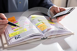 Businessperson Writing Schedule In Diary