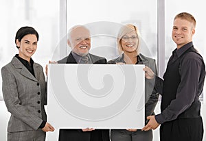 Businessteam holding blank poster