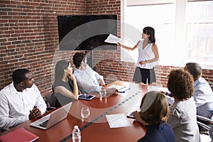 Businesswoman Addressing Boardroom Meeting With Screen