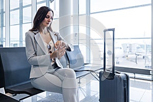 businesswoman at airport checking time as the flight is delayed