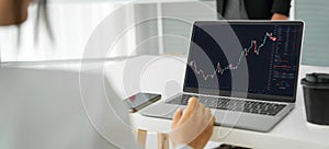 Businesswoman in analyze stock market data using laptop computer proficiently