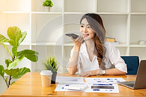 Businesswoman analyzing and brainstorming data, charts, financial reports in the office with laptop and calculator. Ideas for work