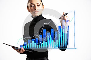 Businesswoman analyzing data on virtual screen while holding tablet