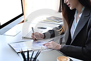 Businesswoman analyzing financial reports at her office desk.