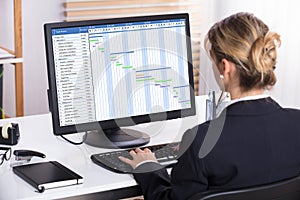 Businesswoman Analyzing Gantt Chart On Computer